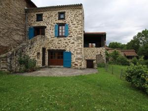 a stone house with blue doors and a yard at Maison de caractère avec terrasse à 300m de l'Allier, idéale pour pêche, détente et activités familiales - FR-1-582-208 in Villeneuve-dʼAllier