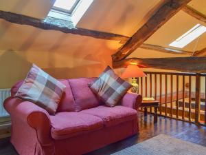 un soggiorno con divano viola in mansarda di Birkerthwaite Barn-W41478 a Eskdale