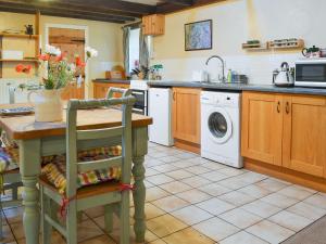 una cucina con tavolo e lavatrice di Birkerthwaite Barn-W41478 a Eskdale