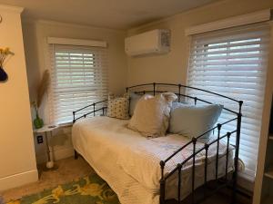 a bedroom with a bed with pillows and windows at The Driftwood Den in Snow Hill