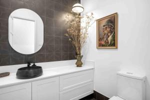 La salle de bains est pourvue d'un miroir et d'un lavabo blanc. dans l'établissement Burrugin Lodge, à Beaumont 23 autres photos