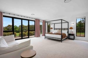 une chambre avec un lit, un canapé et des fenêtres dans l'établissement Burrugin Lodge, à Beaumont