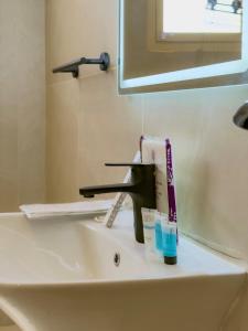 a bathroom sink with a faucet and toothpaste at Spacious apartment next to the financial towers B10 in Quai +15 photos
