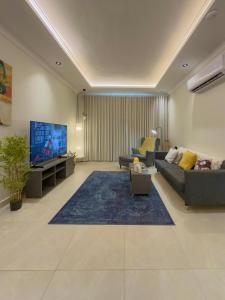 a living room with a couch and a tv at Spacious apartment next to the financial towers B10 in Quai