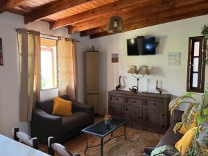 ein Wohnzimmer mit einer Couch und einem Fernseher an der Wand in der Unterkunft Las chochitas 6p in Punta Del Diablo