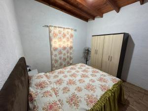 ein Schlafzimmer mit einem Bett, einem Vorhang und einem Schrank in der Unterkunft Las chochitas 6p in Punta Del Diablo