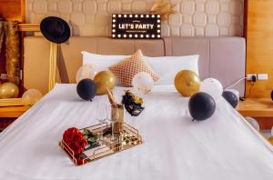 a bed with balloons and a tray on it at Tainan Weshare Hotel in Tainan +168 photos