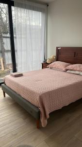 a bedroom with a bed with pink sheets and a window at Apartamento nuevo en Cochrane in Cochrane