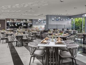 a dining room with tables and chairs in a restaurant at Novotel Suites Manila at Acqua in Manila