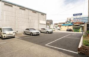 two cars parked in a parking lot next to a building at 전주 케이비호텔 in Jeonju