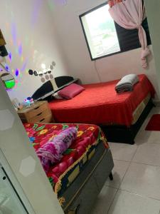 a bedroom with two twin beds and a window at Pousada Duda Lins in São Vicente