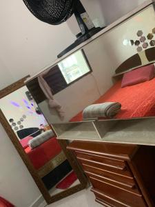 a mirror reflection of a bed in a room at Pousada Duda Lins in São Vicente