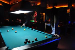 a woman standing next to a pool table at Gulf Gate Hotel in Manama