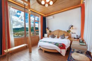 een slaapkamer met een bed en een groot raam bij The Peak Living in Shangri-La