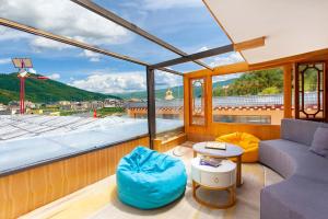 een kamer met een bank, een tafel en een raam bij The Peak Living in Shangri-La