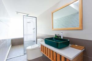 een badkamer met een groene wastafel en een toilet bij The Peak Living in Shangri-La +65 foto's