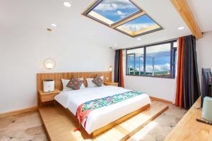 a bedroom with a bed and a large window at The Peak Living in Shangri-La