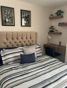 a bedroom with a bed with a striped comforter at Cozy & Modern Apartment in Lirios de Miraflores in Tegucigalpa +19 photos