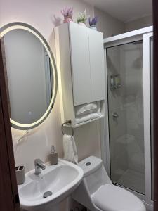 a bathroom with a sink and a toilet and a mirror at Cozy & Modern Apartment in Lirios de Miraflores in Tegucigalpa