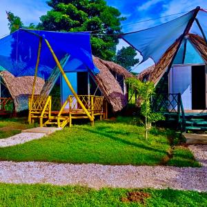 a house with a thatched roof and a porch at Glamping Tesoro Escondido in San Antero