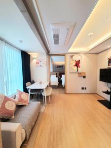 a living room with a couch and a table at 해운대호텔 엘본더스테이 in Busan