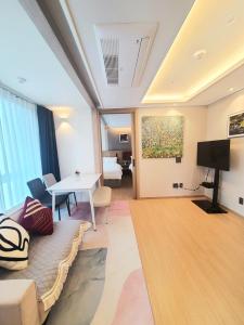 a living room with a couch and a table at 해운대호텔 엘본더스테이 in Busan