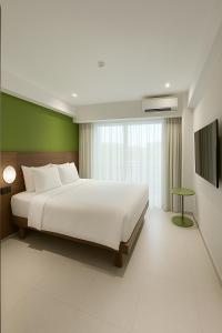 a bedroom with a large white bed and a green wall at Ion Bali Benoa in Nusa Dua