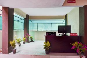 an empty lobby with potted plants and a television at Hotel O Sai Residency in Wagholi