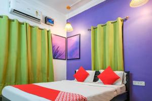 a bedroom with purple and green curtains and a bed at Hotel O DREAM INN in Khandagiri
