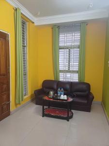 a living room with a leather couch and a table at Hotel O DREAM INN in Khandagiri