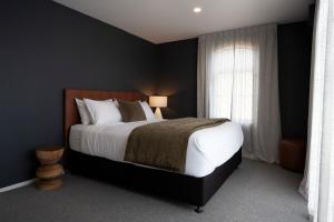 a bedroom with a large bed and a window at The Kings Domain, DUCHESS - Luxurious townhouse in the CBD! in Blenheim