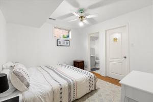 a white bedroom with a bed and a ceiling fan at Home Away From Home in Richmond Hill