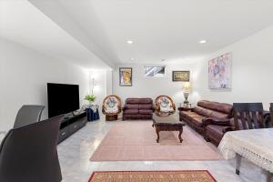 a living room with leather furniture and a flat screen tv at Home Away From Home in Richmond Hill