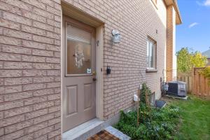a brick house with a door with a skeleton in the window at Home Away From Home in Richmond Hill