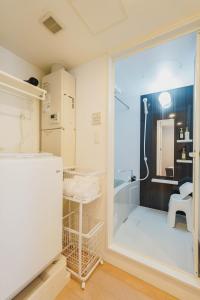 ein Badezimmer mit Dusche und Kühlschrank in der Unterkunft Ｂｒａｎｃｈｅ住吉ＥＡＳＴ in Fukuoka