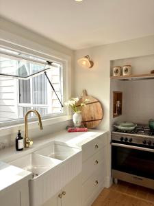 a kitchen with a sink and a stove at Koroit Street Cottage in Warrnambool +17 photos
