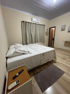 a small bedroom with a bed and a table at Hotel Real Ipiranga in Três Marias