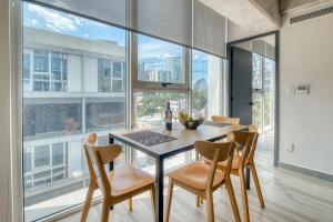 a dining room with a table and chairs and a large window at Nido x Nomad Pablo Neruda GDL in Guadalajara