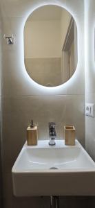 a bathroom with a sink with a round mirror at Da Nonno Mario in Bagnoli Irpino