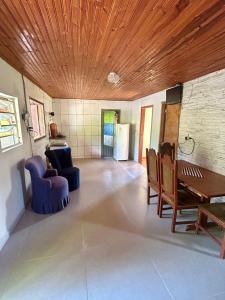 サン・トメー・ダス・レトラスにあるSitio Vale das Montanhasの木製の天井のリビングルーム(テーブル、椅子付)