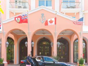 un hombre parado frente a un edificio con banderas en Hamilton Princess & Beach Club A Fairmont Managed Hotel, en Hamilton