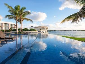 ハミルトンにあるハミルトン プリンセス ＆ ビーチ クラブ ア フェアモント マネージド ホテルのヤシの木と大きな水域のあるプール