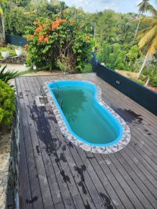 a swimming pool on a wooden deck with a blue swimming pool at Mountvilla Exquisite 4-Bedroom Luxury Retreat with Private Pool in Galle