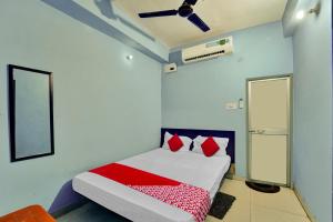 Un dormitorio con una cama con almohadas rojas. en Hotel O Glad Guest House, en Patna