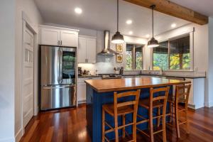 a kitchen with a blue island in a kitchen with a refrigerator at Evergreen Retreat AB 30 Night Minimum home in White Salmon