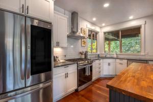 a kitchen with white cabinets and a stainless steel refrigerator at Evergreen Retreat AB 30 Night Minimum home in White Salmon
