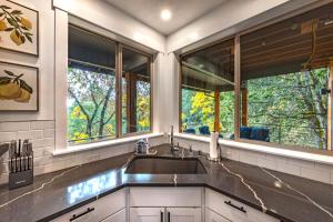 a kitchen with a sink and two windows at Evergreen Retreat AB 30 Night Minimum home in White Salmon