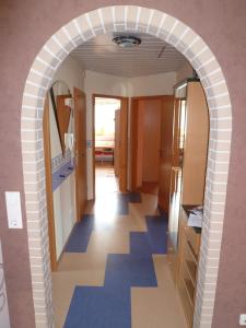 an archway in a hallway with blue flooring at Ahornweg Ferienwohnung in Gebsattel
