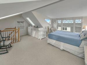 een slaapkamer met een bed en een stoel op zolder bij Perkins Cove Gem in Ogunquit