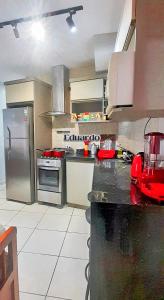eine Küche mit Herd und Kühlschrank in der Unterkunft Apartamento pé na areia no centro de Tramandaí! in Tramandaí